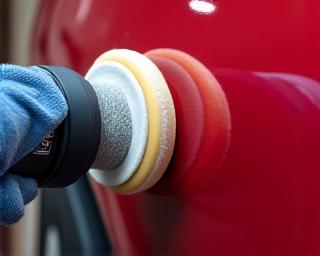 폴리셔를 사용하여 자동차 문을 광택내는 전문가의 손